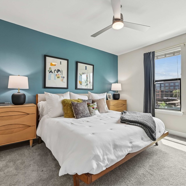 The Arnold - Bedroom with Floor to Ceiling Windows and Cozy Carpeted Flooring