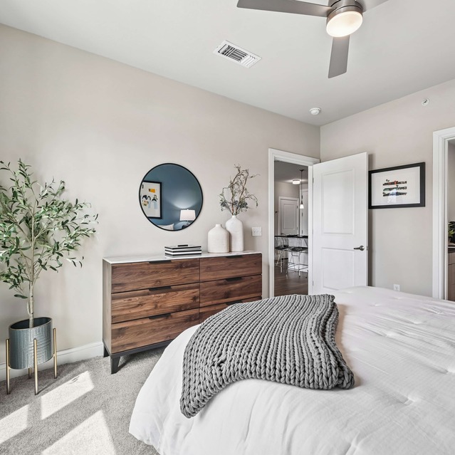 The Arnold - Bedroom with Floor to Ceiling Windows and Cozy Carpeted Flooring