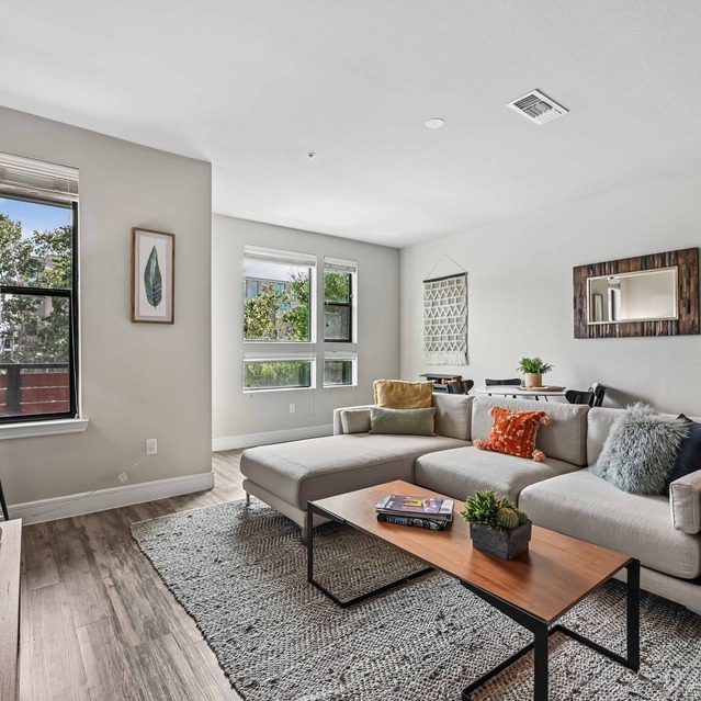 The Arnold - Spacious Living Area with Hardwood Floors and Bright Lighting