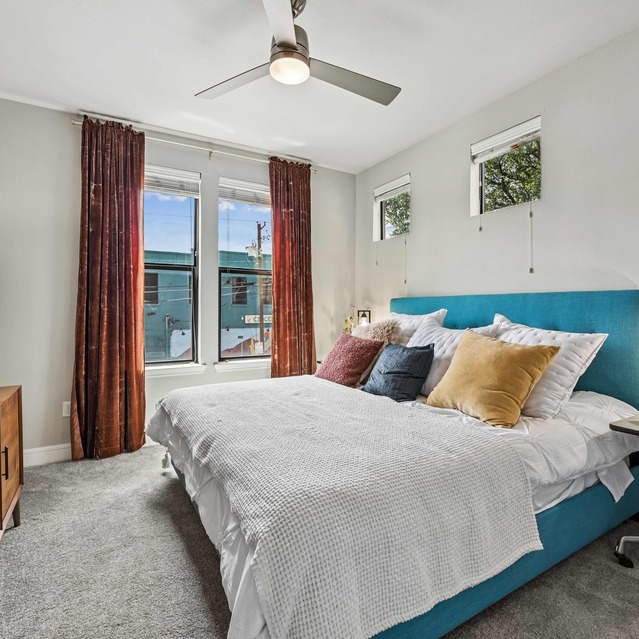 The Arnold - Bedroom with Floor to Ceiling Windows and Cozy Carpeted Flooring